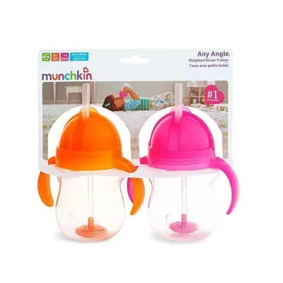 Two Munchkin Any Angle Weighted Straw Trainers in orange and pink, designed for spill-proof drinking, displayed in packaging.