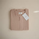 100% organic cotton muslin baby wearable blanket in a natural beige color, folded neatly with a tag.
