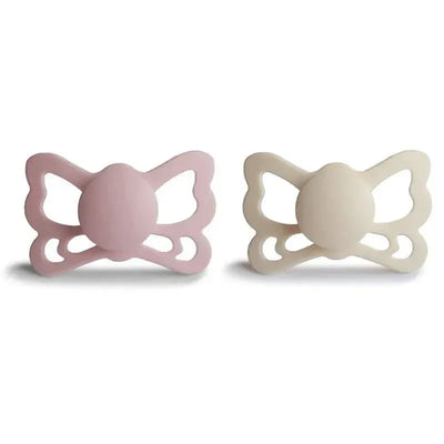 Two silicone pacifiers in cream and blush colors, shaped like butterflies, suitable for infants aged 6 to 18 months.