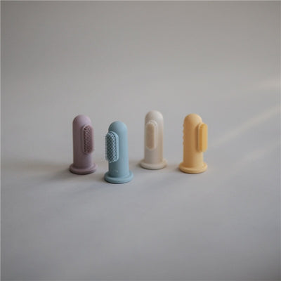 Two soft, silicone finger toothbrushes in lilac and ivory alongside two additional colors, featuring bristles for gentle cleaning.