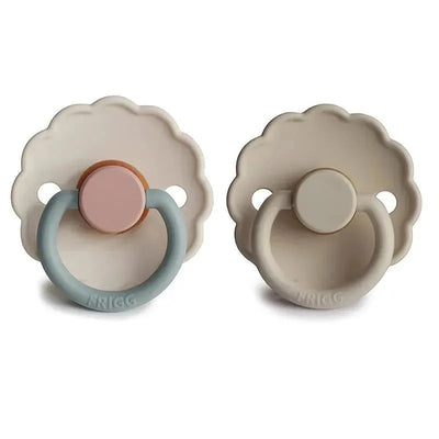 Two Frigg Daisy natural rubber pacifiers in sandstone and cotton candy colors, suitable for infants 0-6 months.