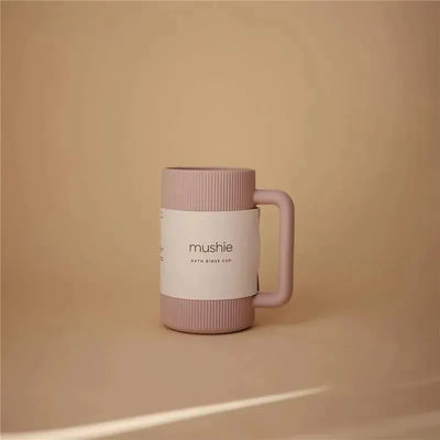 Mushie Bath Rinse Cup in Soft Lilac, featuring a ribbed design and a sturdy handle, displayed against a neutral background.