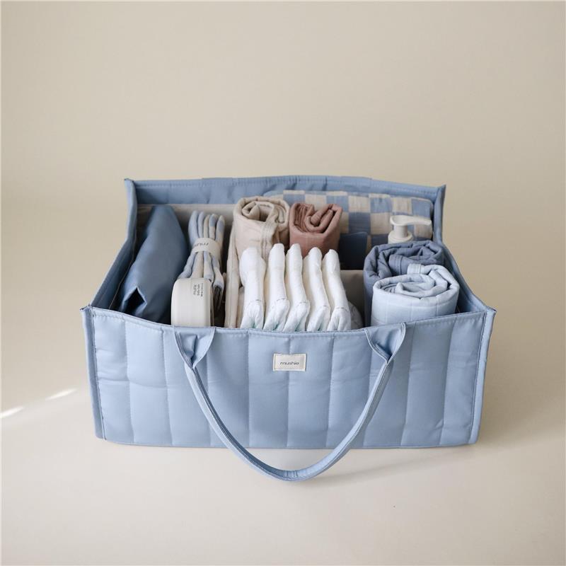 Mushie Baby Diaper Caddy in Tradewinds blue, filled with neatly arranged diapers, cloths, and essentials for newborn care.