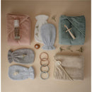Mushie Baby Organic Cotton Hooded Towel and accessories arranged on a soft background, featuring various colors and textures.