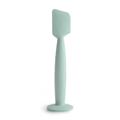 Silicone diaper cream applicator in Cambridge Blue, featuring a textured handle and a flat applicator tip for clean application.