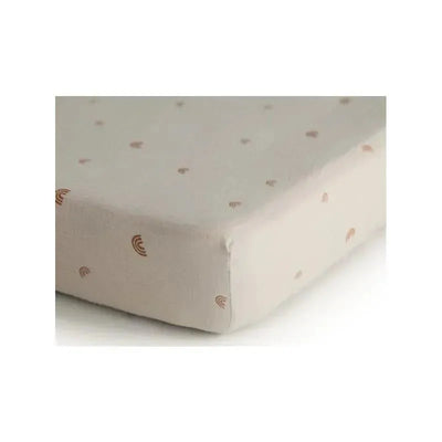Extra soft muslin mini crib sheet featuring a beige color with small rainbow and heart patterns.
