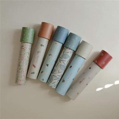 Mushie Kaleidoscope Set featuring six decorative tubes, each with unique designs related to space and dinosaurs.