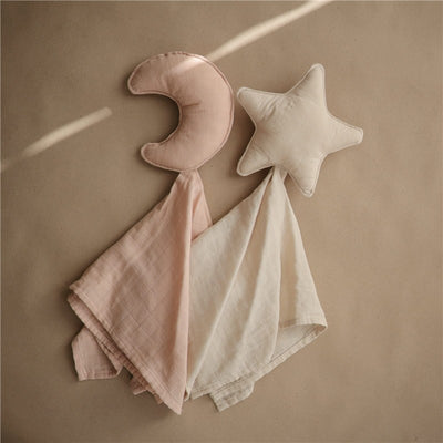 Mushie Moon Lovey in blush featuring a pink crescent moon and a neutral star attached to soft, light-colored fabric.