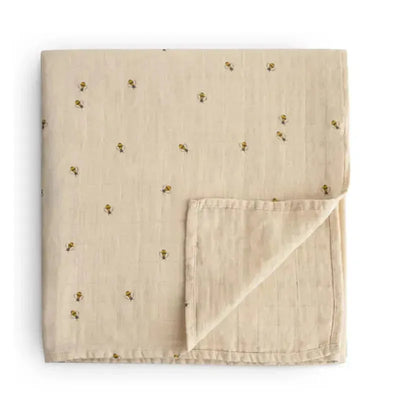 Organic cotton muslin swaddle blanket in beige, featuring a bee pattern, folded with a hemmed edge.