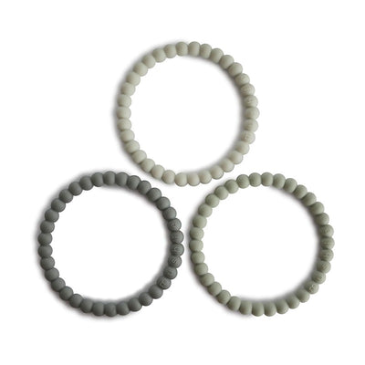 Mushie Pearl Teething Bracelet set in green tea, cool gray, and sea salt colors, designed for soothing teething infants.