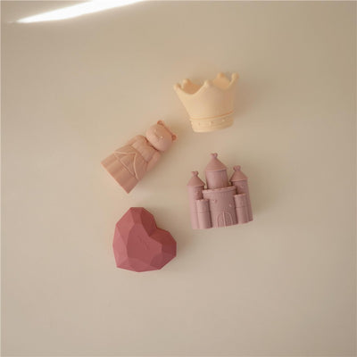 Mushie Princess Mold-Free Bath Play Set featuring a crown, princess figurine, castle, and heart-shaped toy in soft pastel colors.