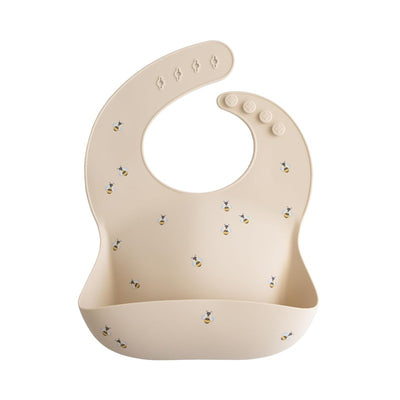 Silicone baby bib in light beige featuring playful bee patterns, designed to catch food spills during mealtime.