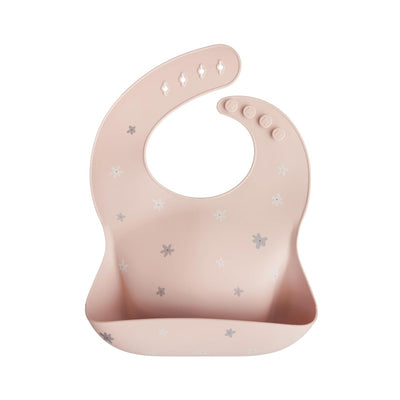 Mushie Silicone Baby Bib in pink with daisy patterns, designed to catch food spills during mealtime.