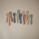 Silicone baby spoons in various pastel colors, designed for first feeding, displayed on a neutral background.