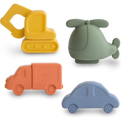 Colorful bath toys including a yellow excavator, green helicopter, orange delivery truck, and blue car from the Mushie Vehicles set.