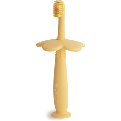 Silicone flower-shaped training toothbrush in daffodil yellow, designed for toddlers with soft bristles.