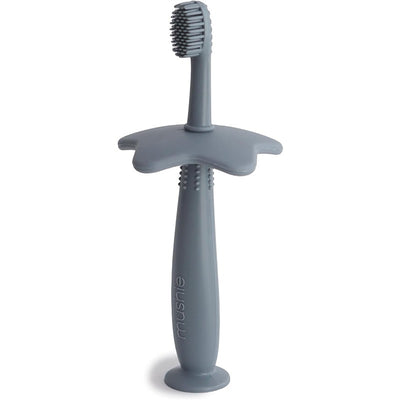 Silicone star-shaped training toothbrush by Mushie in tradewinds color, designed for infants with a textured grip.