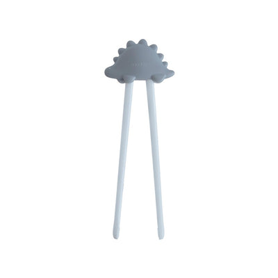 Training chopsticks with a dinosaur-shaped handle, designed for children, in a light gray color.