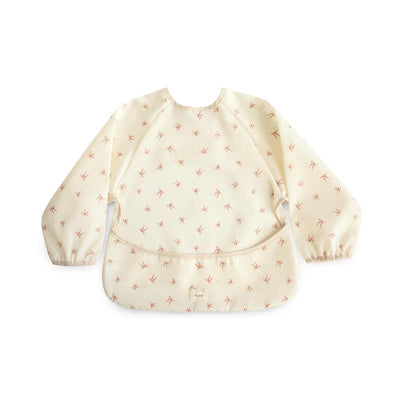 Water-resistant long sleeve baby bib featuring a soft cream background with pink bows, designed for adjustable fit.