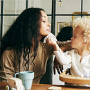 A mother using a Mustela cleansing wipe to gently clean her toddler's face.