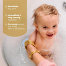Mustela Hair Styler & Skin Freshener held by a parent, featuring a happy child in a bath with bubbles.
