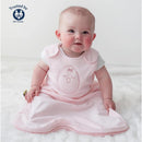 Soft pink Nested Bean Zen Sack Classic with a cute chick design, worn by a smiling baby sitting on a fluffy surface.