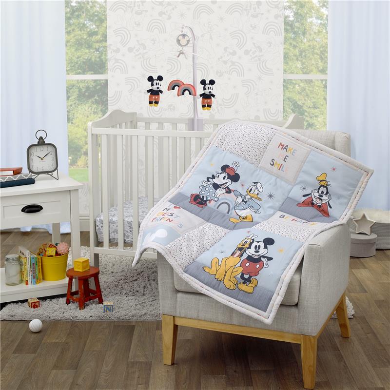 NoJo 3Pk Disney Mini Crib Bedding Set featuring Mickey, Minnie, Donald, and Pluto designs, displayed on a chair with a crib in the background.