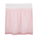 Bedding skirt in soft pink fabric with a white top section and a gold ribbon trim at the bottom.