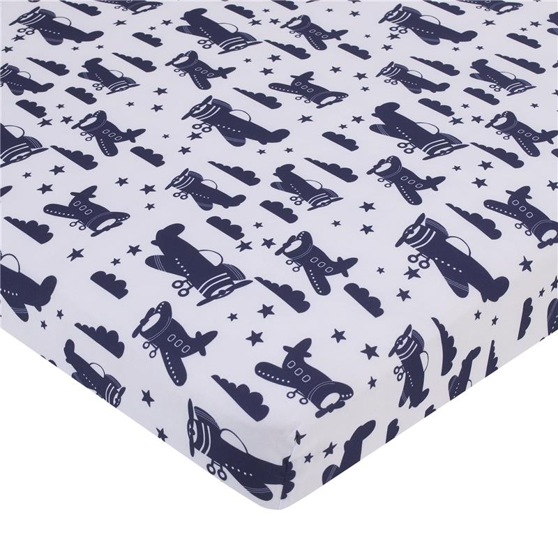 Mini crib bedding featuring a playful navy blue and white pattern of airplanes, clouds, and stars, designed for infants.
