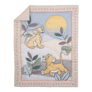 Nursery crib bedding set featuring playful Lion King cubs on a colorful quilt with leaves and a sun.