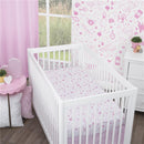 Fitted crib sheet featuring white and pink castle, hearts, and stars design in a nursery setting with pastel decor.