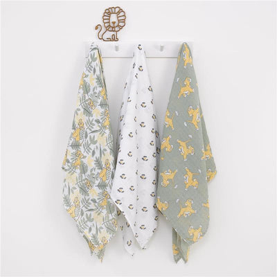 Three Nojo Lion King muslin swaddles hang on a wall: one with zebras and Simba, a solid white one with round patterns, and a green one depicting Simba playing.