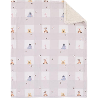 Baby blanket featuring Winnie the Pooh characters on a soft beige background, with a sherpa backing.