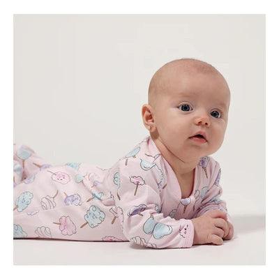 Cotton candy-print baby girl footie in soft cotton, featuring pastel colors and a zipper closure, worn by a crawling infant.