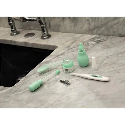 Medical organizer set by Nuby featuring a thermometer, nasal aspirator, and other baby care tools on a marble countertop.