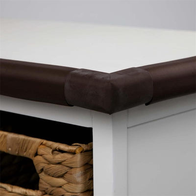 Foam straight edge corner guard in dark brown applied to a white table edge, with woven storage baskets visible below.