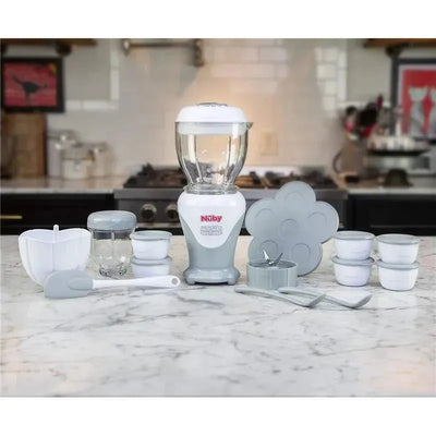 Nuby Garden Fresh Mighty Blender in cool gray, with baby food containers, a spatula, and a flower-shaped mold on a countertop.