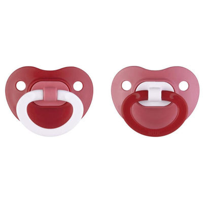 Two assorted red Nuk pacifiers, featuring round shapes and white handles, designed for infants.