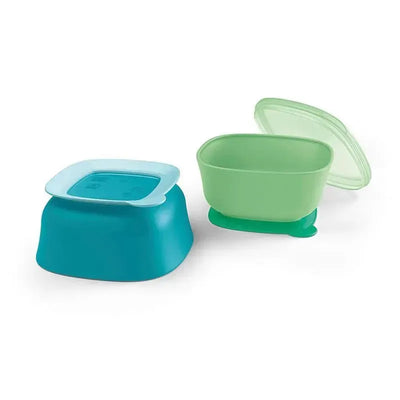Two suction bowls from Nuk in teal and green, featuring a lid on one and a secure base designed to prevent spills.