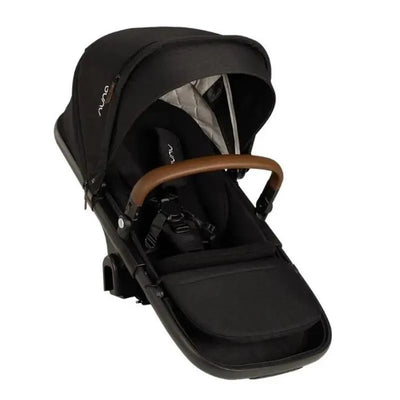 Nuna DEMI next Sibling Seat in Caviar, featuring a black fabric exterior, adjustable canopy, and a brown handlebar.