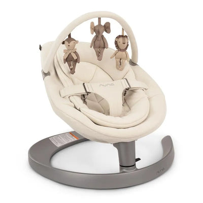 Nuna LEAF™ grow Baby Seat & Rocker in Cloud color, featuring a soft fabric seat and hanging toy attachments of animals.