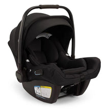 Nuna Pipa Aire Rx Infant Car Seat in Caviar/Chocolate, featuring a secure harness, removable canopy, and safety instruction label.