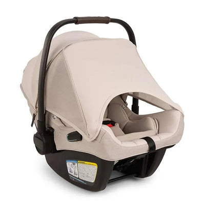 Nuna PIPA™ aire rx Infant Car Seat in Biscotti color, featuring a protective canopy and safety harness.