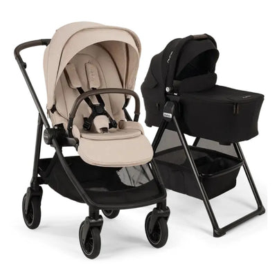 Nuna Swiv stroller in Biscotti color beside a black Swiv bassinet on a stand, showcasing baby gear design and functionality.