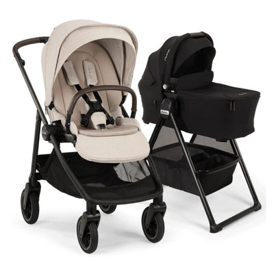 Nuna Swiv stroller with a beige seat and black frame next to a black Swiv bassinet on a stand, designed for infants.