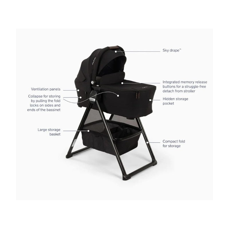 Nuna Swiv Bassinet on a stand, featuring ventilation panels, storage basket, and integrated release buttons for easy detachment.