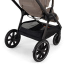 Nuna Triv LX stroller with a spacious black storage basket and sleek, modern wheels, designed for convenience and style.