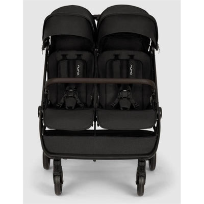 Lightweight Nuna TRVL Dubl side-by-side double stroller in Caviar color, featuring two seats with harnesses and canopy.