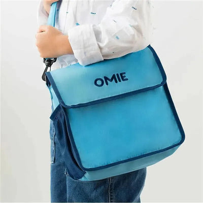 Blue insulated nylon lunch tote by Omie, featuring a flap closure and the brand logo on the front.