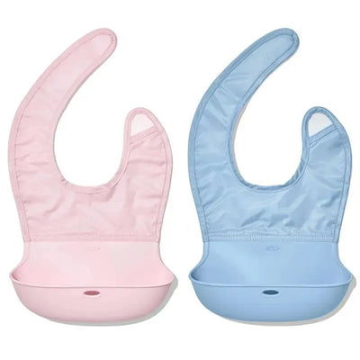 Two silicone bibs in pink and blue with a catch-all pocket, designed for toddlers, by Oxo.